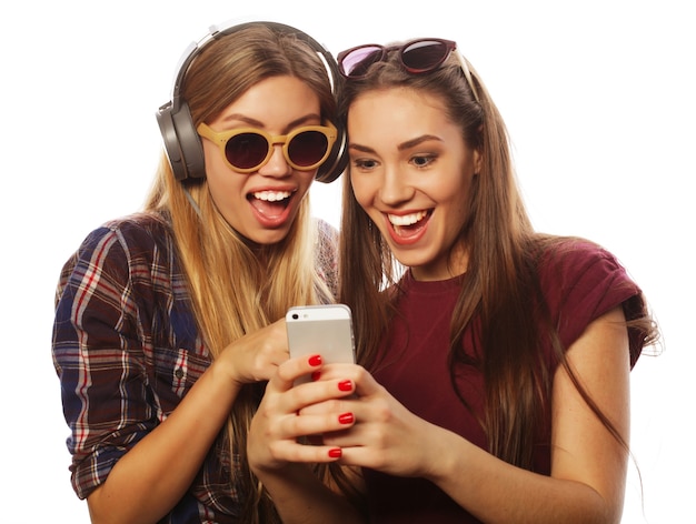 Two teenage girls friends in hipster outfit make selfie on a phone.