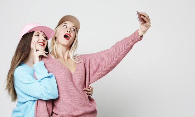 Two teenage girls friends in hipster outfit make selfie