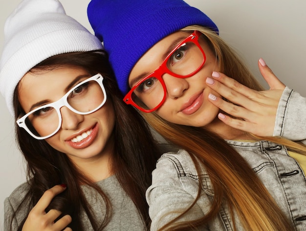 Due ragazze adolescenti amiche in abiti hipster si fanno un selfie