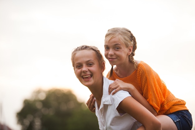 写真 2人の10代の少女が公園で楽しんでいます。屋外の2人の友人。眼鏡をかけた夏の人々