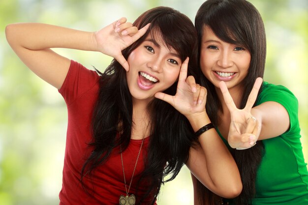 Two teenage girls hugging and posing