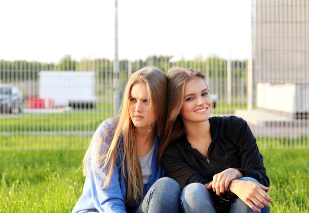 Two teenage girls sitting together outdoors