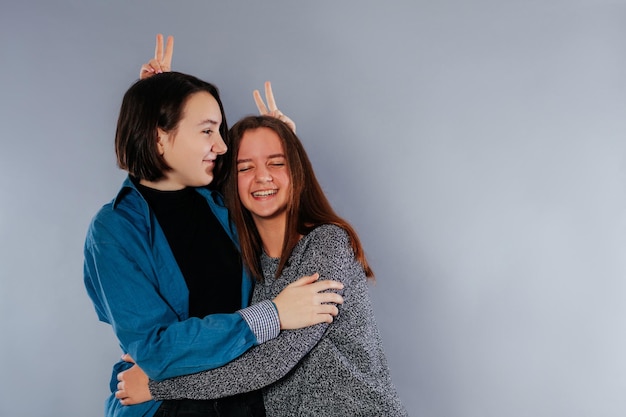 Two teenage sisters are hugging each other