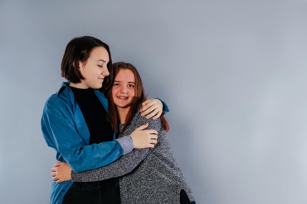 Two teenage sisters are hugging each other