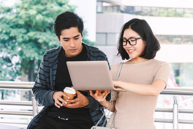 Two teenager students doing homework with laptop at university