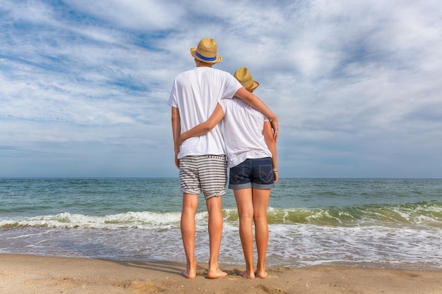 Two teenagers a girl and a boy are standing on the sea beach