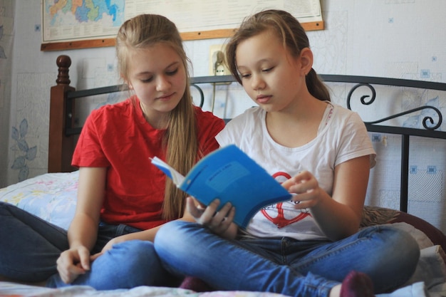 Two teenagers girls at home makes homework, close up