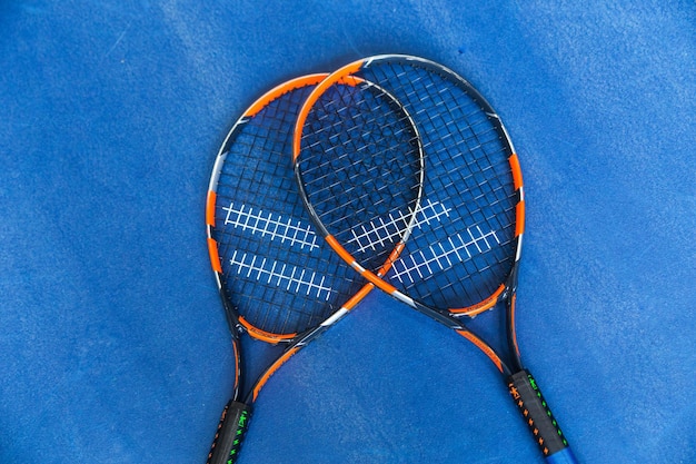 파란색 배경에 두 개의 테니스 라켓 상위 뷰 가로 사진