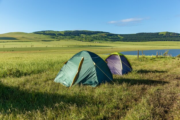 水、風景の近くの牧草地にある2つのテント。 2つのテント、landscape.journey to Georgia