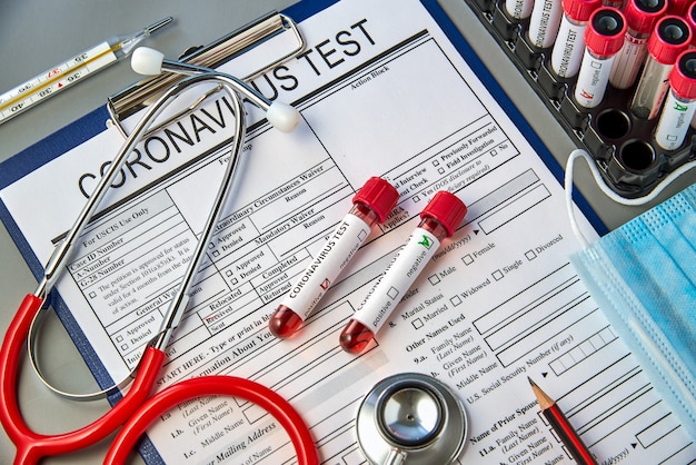 Two test tubes with blood samples for the COVID-19 test on the coronavirus test form.  