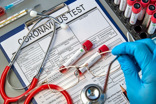 Two test tubes with blood samples for the COVID-19 test on the coronavirus test form.  