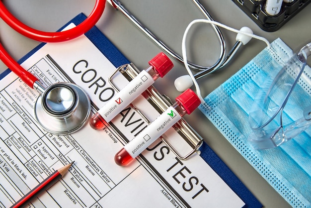 Two test tubes with blood samples for the COVID-19 test on the coronavirus test form.  