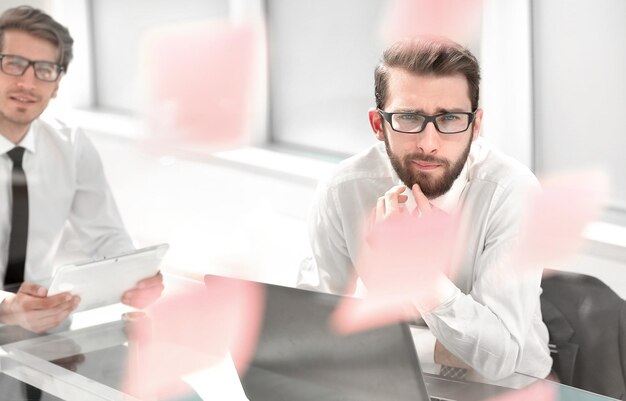 Photo two thoughtful employees sitting at a desk