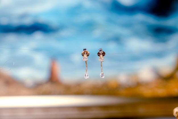 two tiny silver hooks are shown with the background of a blue sky
