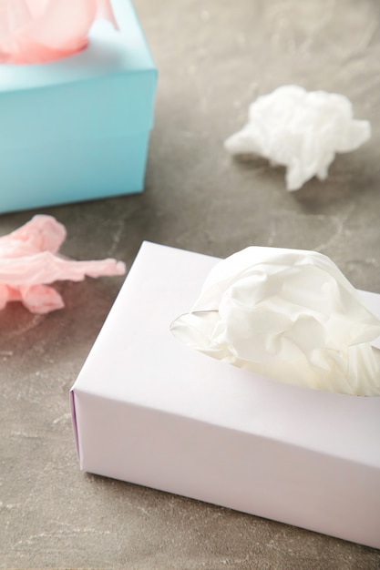 Two tissue box on grey background.