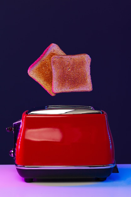 Photo two toast slices jumping out of toaster in neon light