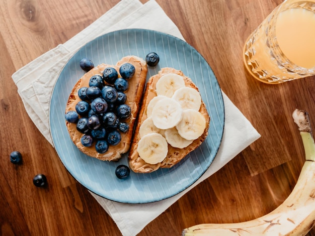 Two toasts with peanut butter blueberry and banana Healthy breakfast concept top view