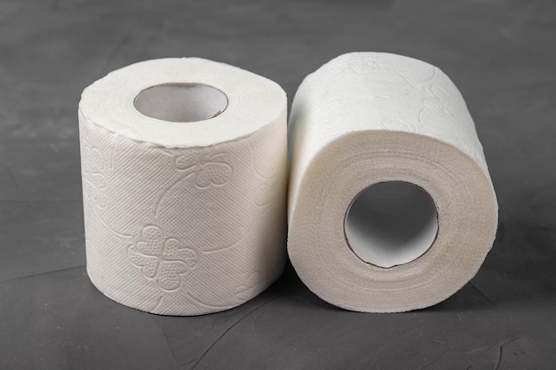 Photo two toilet paper rolls on a gray background