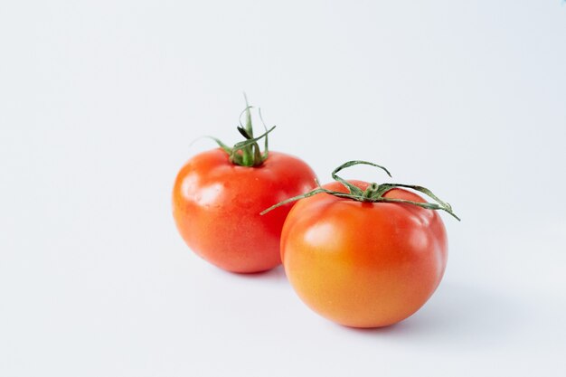 Two tomatoes isolated on a white background, tomato close-up