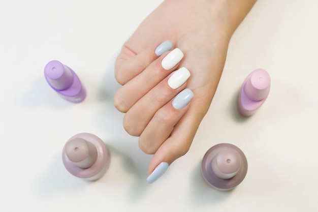 two-tone manicure with blue and white nail polish and nail polish bottles