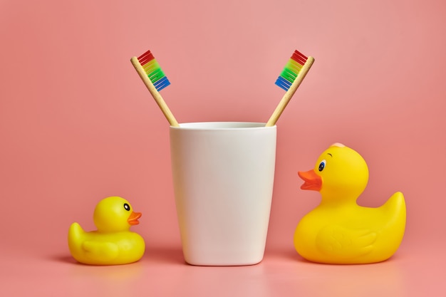 Two toothbrush and bathroom duck toys. LGBT personal care concept. Protect oral cavity, remove plaque and tartar.