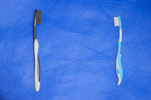 Two toothbrushes for adults and children on isolated on blue background