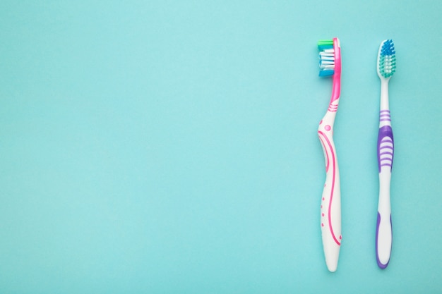 Two toothbrushes on blue background