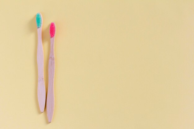 Two toothbrushes made of natural wood on a light beige background top view The concept of natural dental care Space for copying