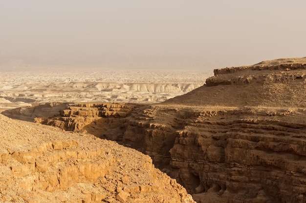 Two tourists walk among the rocks of the Judean Desert.