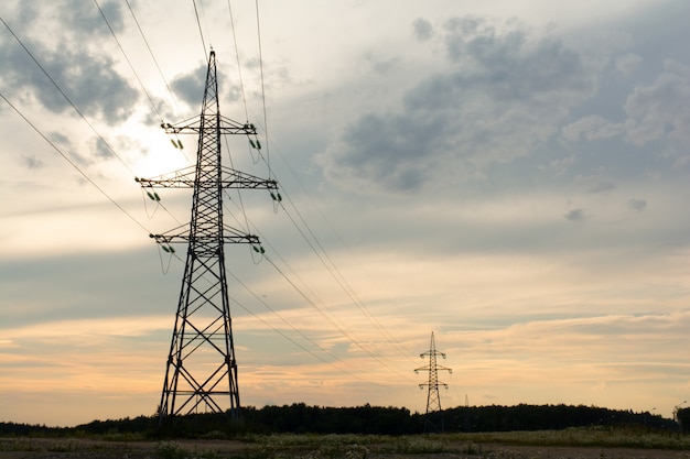 Two towers of high-voltage transmission lines on sunset