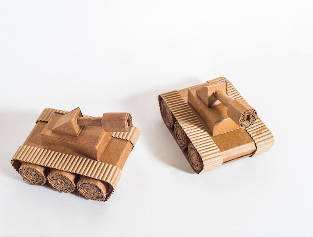 Due carri armati giocattolo realizzati da bambini in cartone ondulato stanno combattendo
