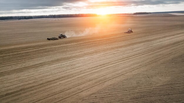 Two tractors plowing the field at sunrise Agriculture view aerial photography