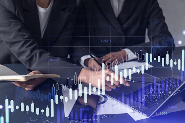 Two traders researching historic data to predict stock market behavior Women in trading business concept Forex and financial hologram chart over the table with the document