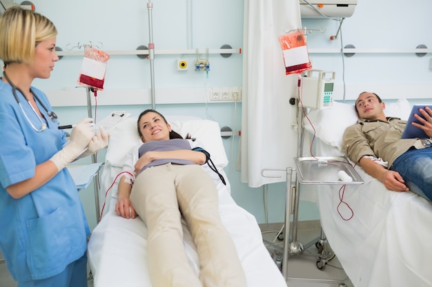 Photo two transfused patients looking at a nurse