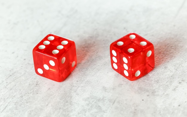 Photo two translucent red craps dices on white board showing easy ten (number 6 and 4)