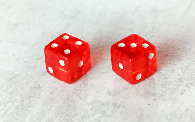 Два полупрозрачных красных кубика для игры в кости на белой доске с изображением Natural или Seven Out (номера 4 и 3)