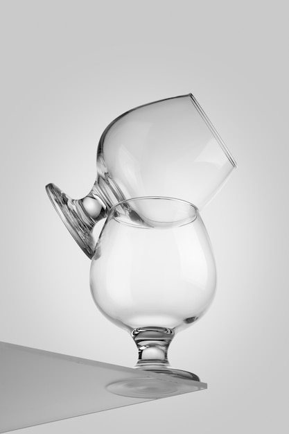 Two transparent glass cognac glasses on top of each other isolated on white background. Pyramid of groceries. White background.