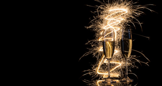 Foto due bicchieri di champagne trasparenti alle luci del bengala