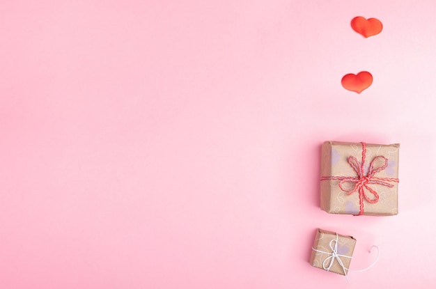 Two trendy diy wrapped gift boxes and two red hearts. Valentine's day festive flat lay