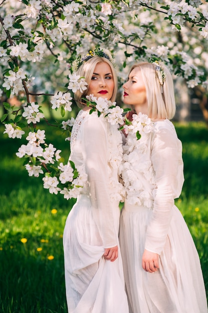 two twin sisters in a cherry orchard