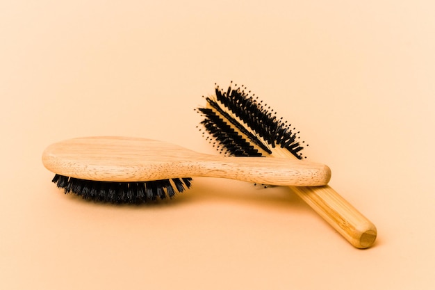 Photo two types of hairbrush isolated on beige background