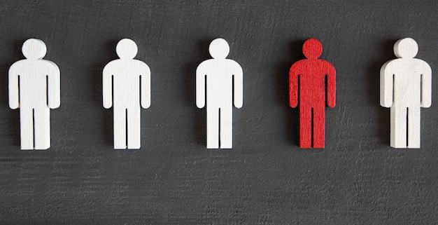 Two types of wooden persons on the wooden table red and white