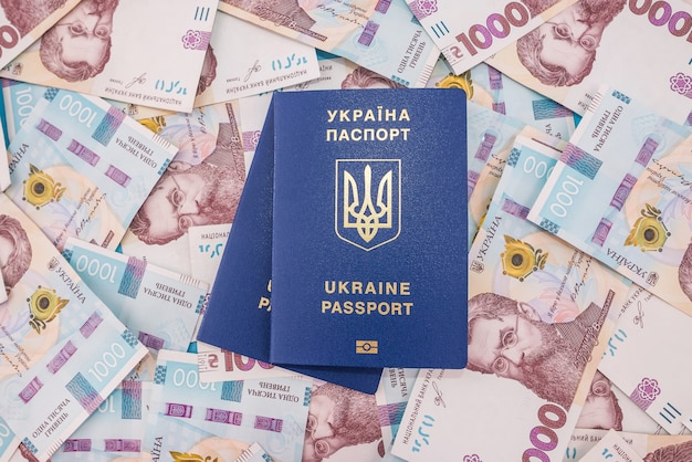 Two Ukrainian passports on hryvnia background