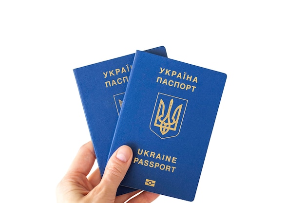 Two Ukrainian passports in a woman's hand on a white background