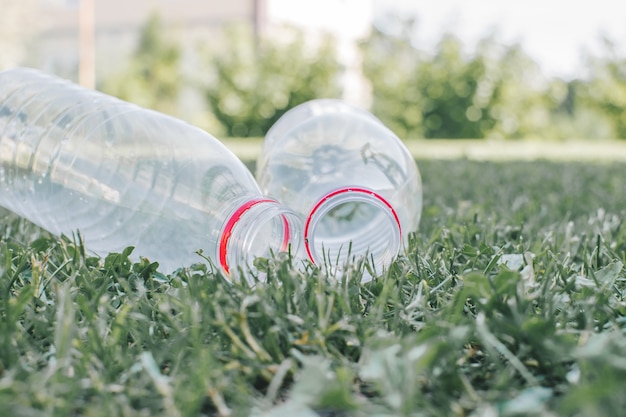 Due bottiglie di plastica usate sullo sfondo dell'erba