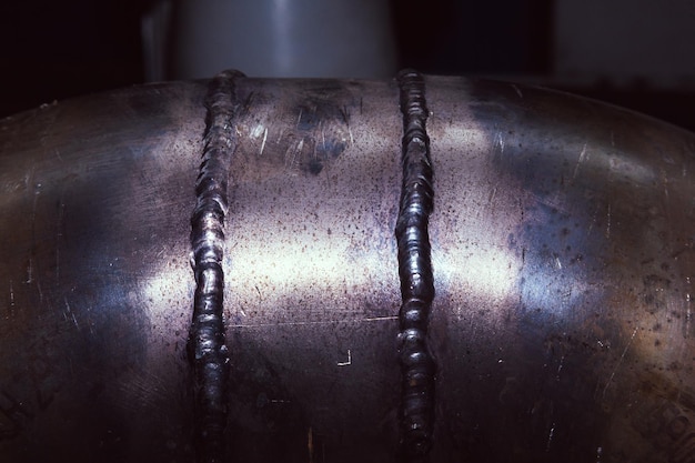Two vertical welds on a stainless steel pipe closeup