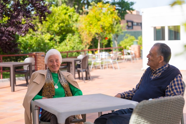 Photo two very cheerful elderly people in the garden of a nursing home resting in the morning on a sunny summer day