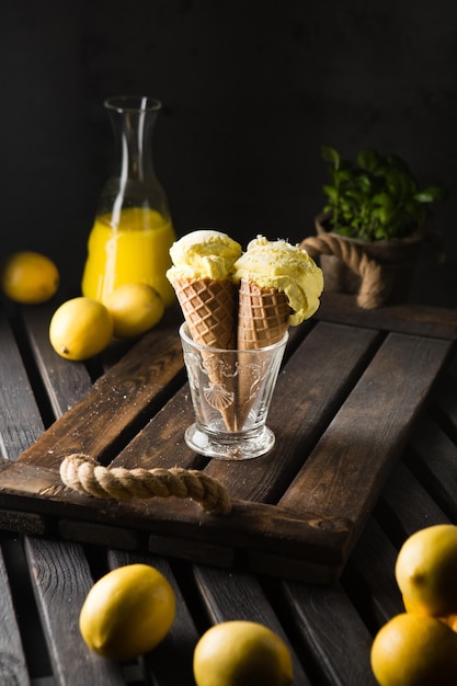 Foto due coni di cialda con gelato al limone su sfondo scuro