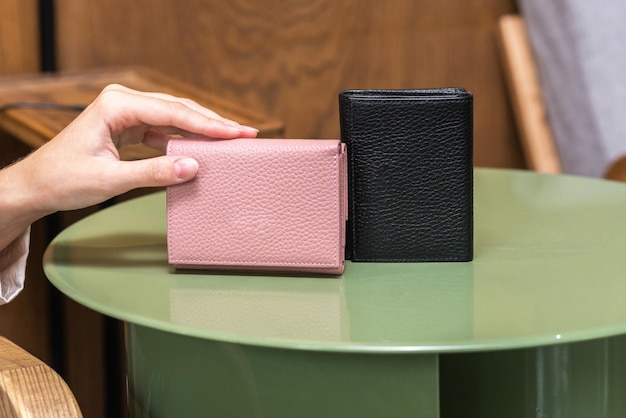 탁자 위에 있는 한 소녀의 손에 있는 두 개의 지갑