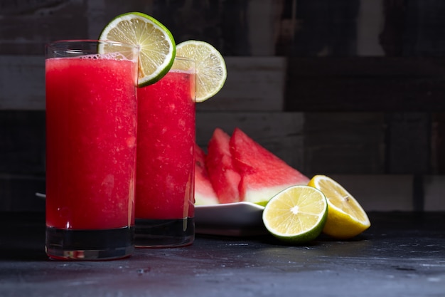 Two watermelon cocktails with lemon and lime slices